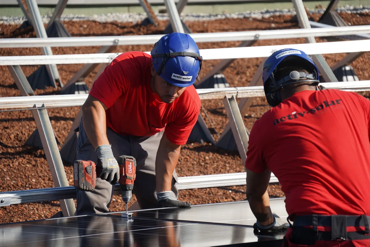 Monteure befestigen die Solarpanels.